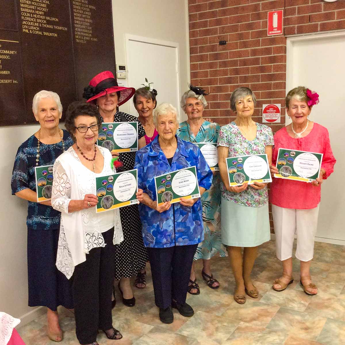 Volunteers holding their certificates acknowledging over 20 years of service